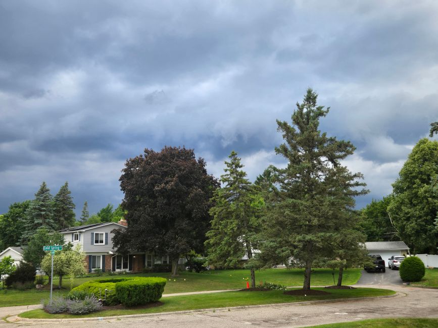 A suburban neighbourhood under dark storm clouds.